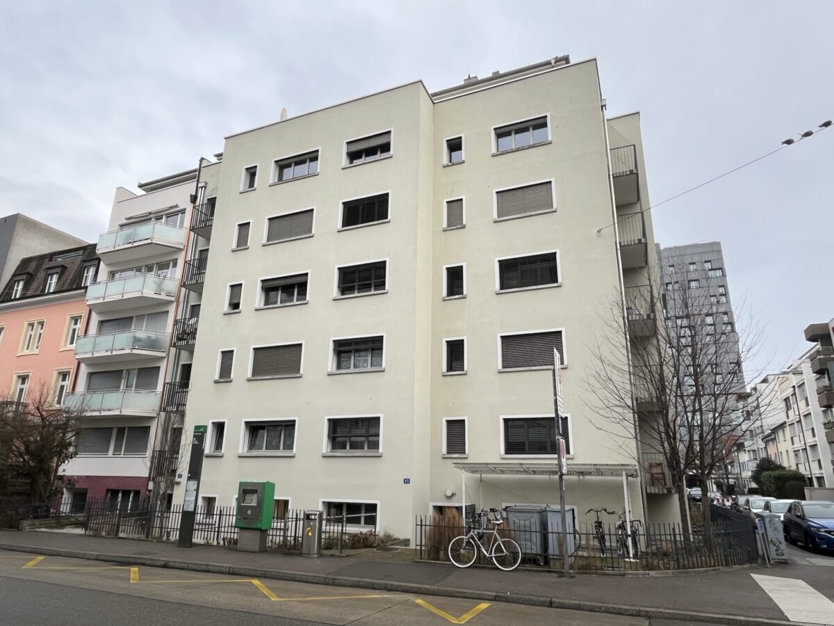 Ein mehrstöckiges Wohngebäude mit mehreren Fenstern und einem Fahrrad davor.