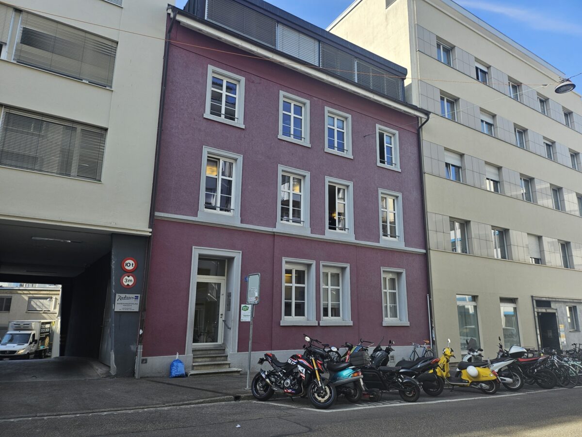 Ein Gebäude mit mehreren Motorrädern davor auf der Straße geparkt.