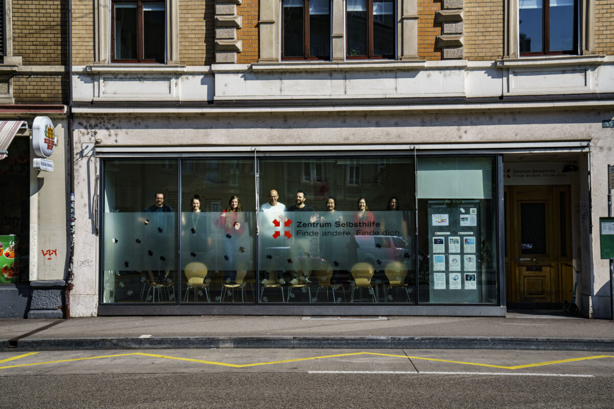 Ein Selbsthilfezentrum mit einem Gruppenfoto im Schaufenster.