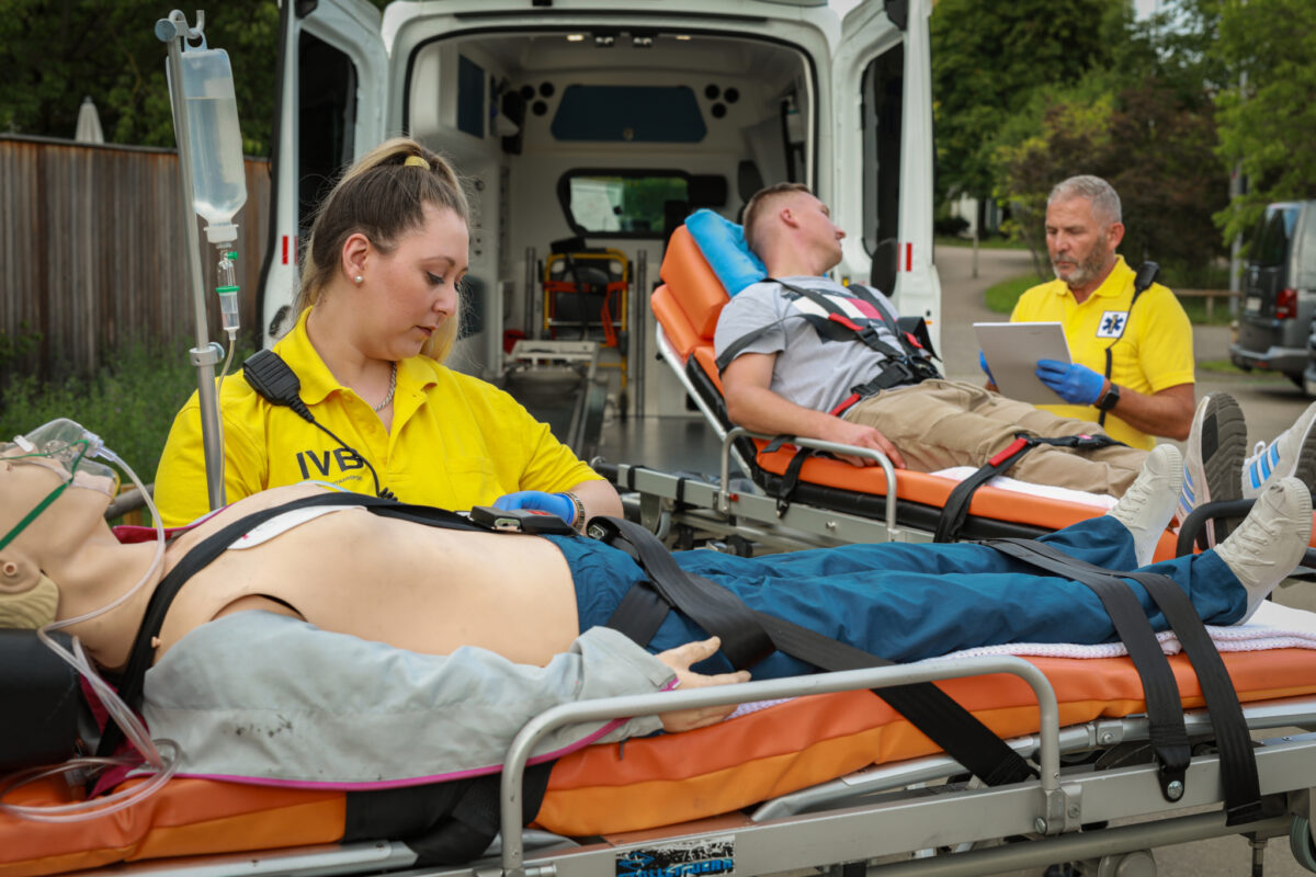 Sanitäter behandeln eine Patientin auf einer Trage in einem Rettungswagen.