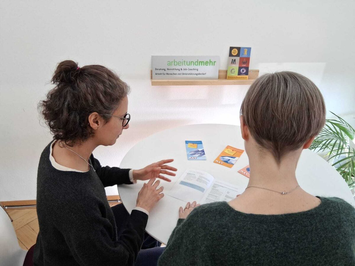 Zwei Personen besprechen Unterlagen in einem Beratungsgespräch.