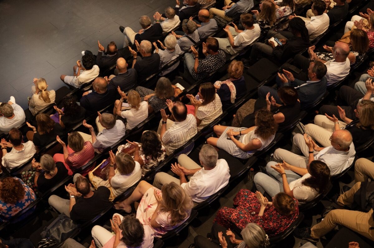 Eine Gruppe von Menschen klatscht in einem Auditorium.