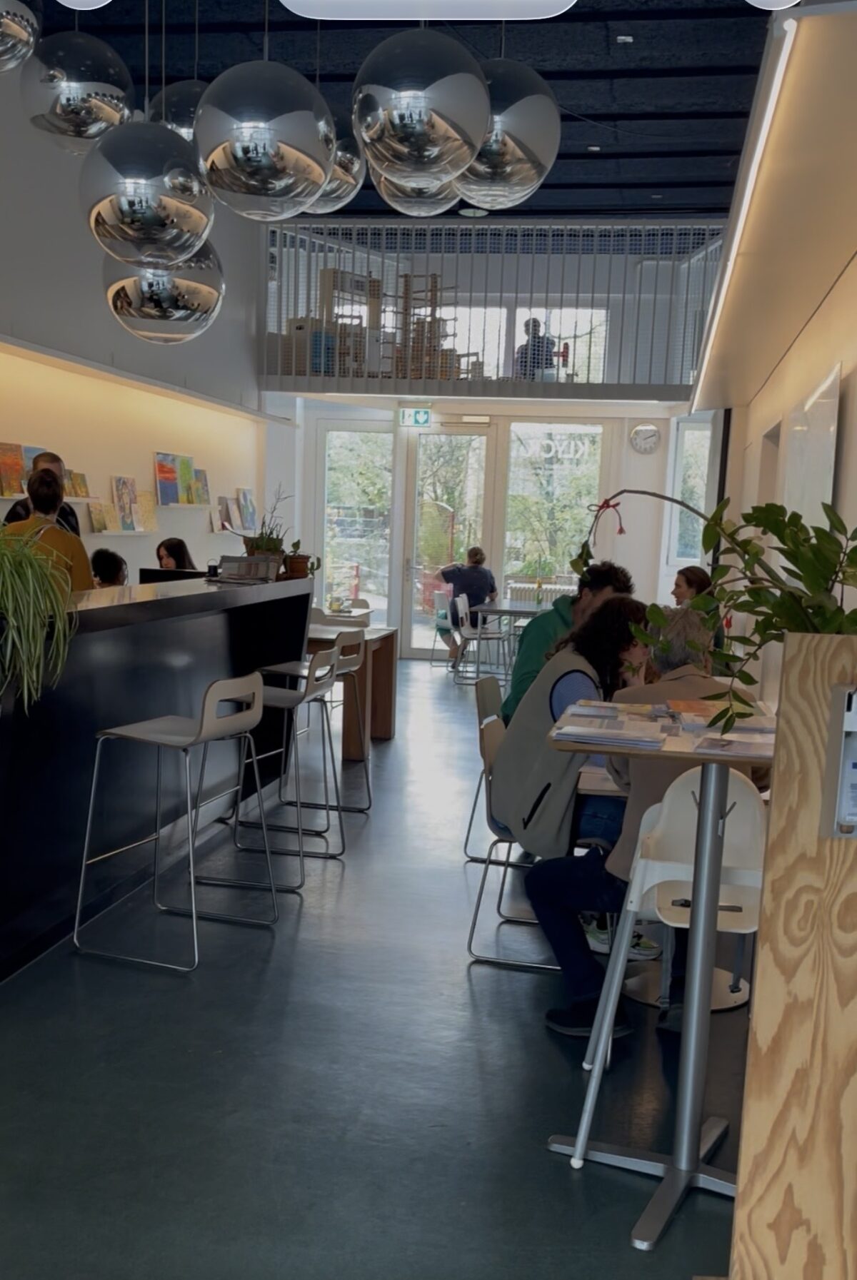 Ein moderner Raum mit Menschen, die an Tischen arbeiten und sich unterhalten.