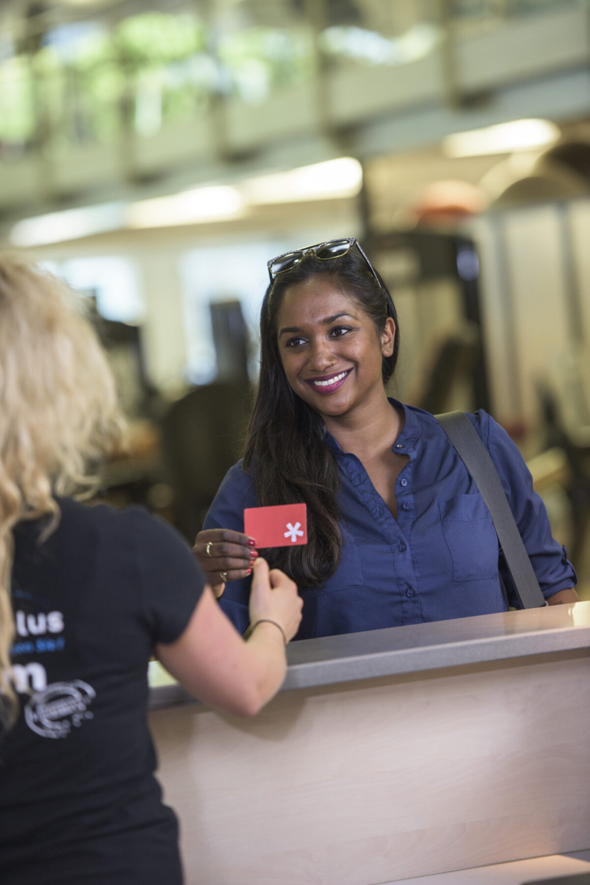 Eine lächelnde Frau erhält einen roten Zettel mit einem Stern von einer anderen Person.