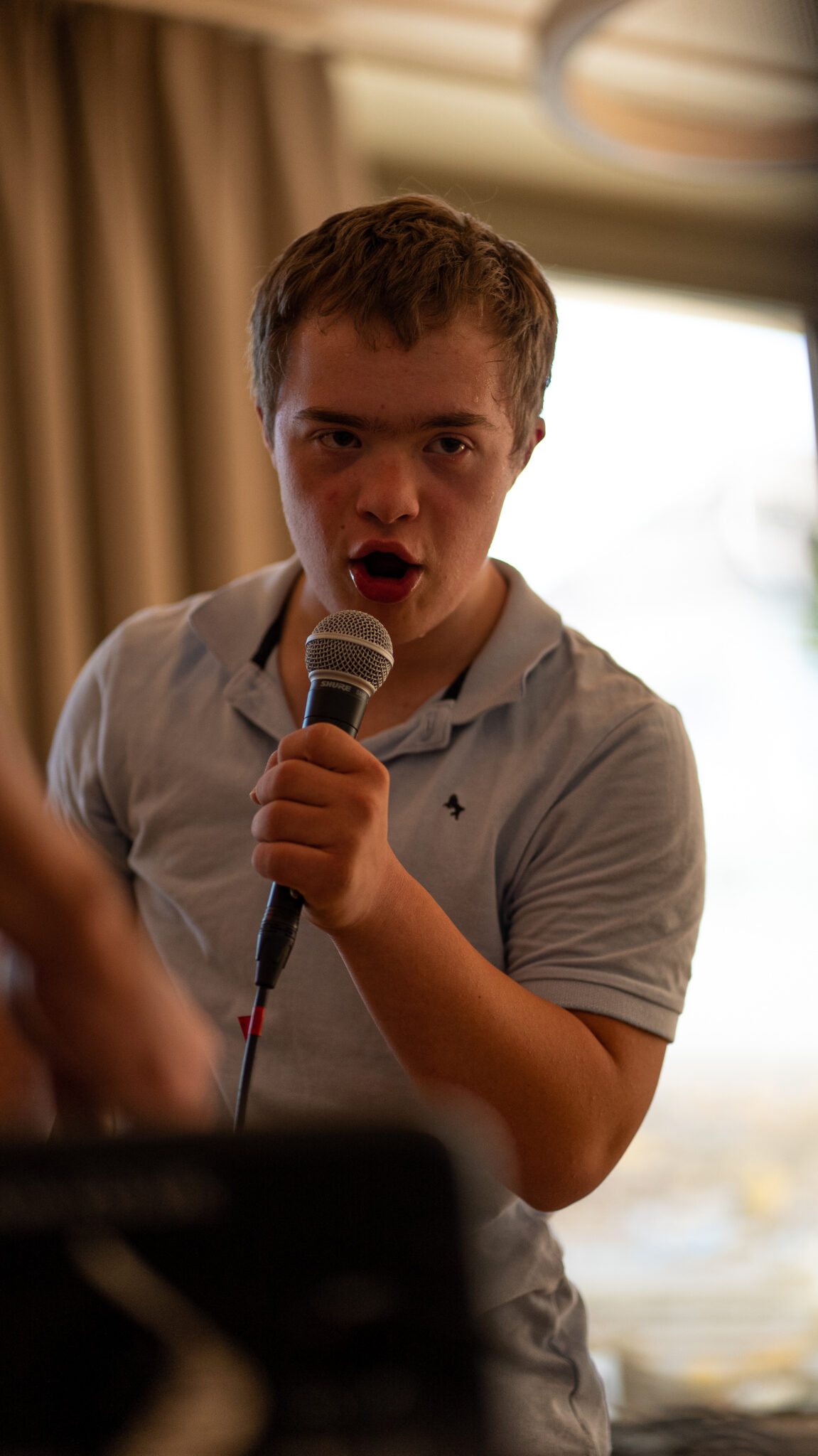 Ein junger Mann spricht mit einem Mikrofon in der Hand.