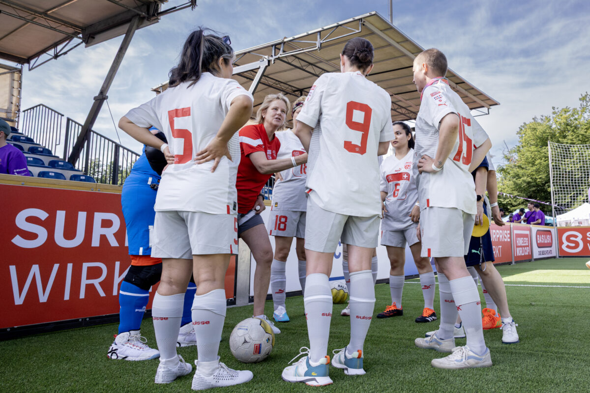 Eine Fußballmannschaft hört der Trainerin aufmerksam zu.