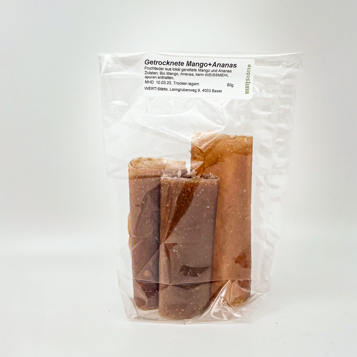 Eine transparente Tüte mit getrockneten Mango- und Ananasstücken.