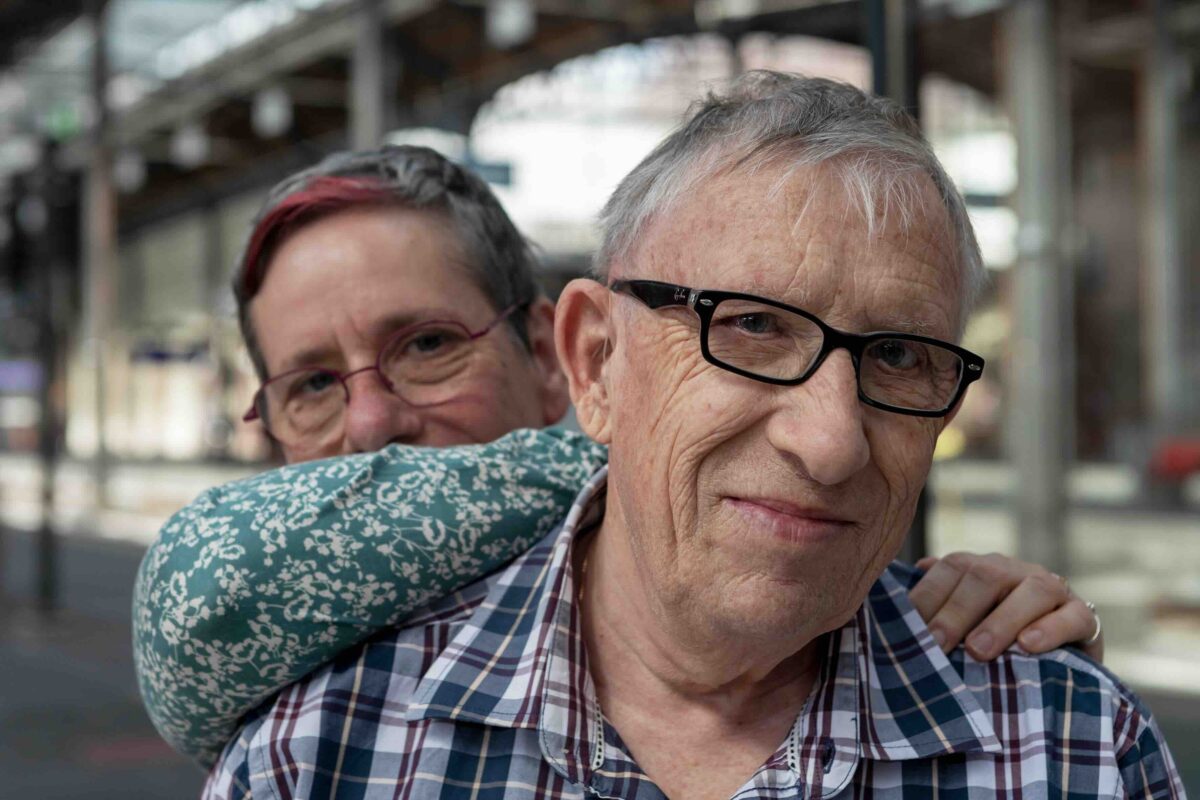 Zwei ältere Personen lächeln sich liebevoll an.