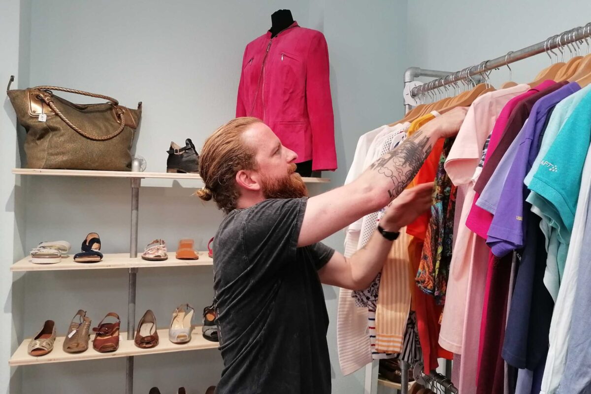 Ein Mann wählt Kleidung in einem Geschäft aus.